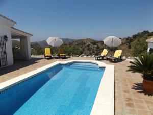 einen Pool mit Stühlen und Sonnenschirmen auf einem Haus in der Unterkunft Casa Almendros in Sedella