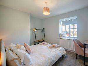 a bedroom with a bed with pillows and a window at 2 Bed in Newbiggin-by-the-Sea 83568 in Newbiggin-by-the-Sea