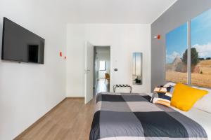 バーリにあるJust Here apartments - Ninaのベッドルーム1室(ベッド1台、壁にテレビ付)