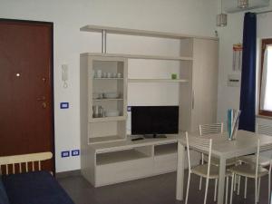 a room with a desk with a television and a table at Flat House in Fiumicino