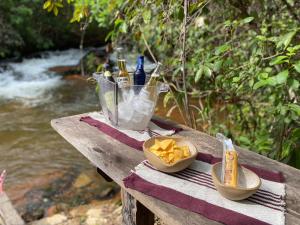 a picnic table with drinks and chips and a bowl of chips at Casa Saracura in Aguaçu