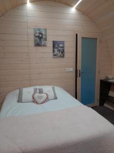 a bedroom with a bed with a heart pillow on it at " village tonneaux de tirpoil " in Montilliers