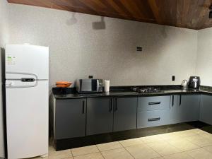 uma cozinha com um frigorífico branco e um fogão em Mansao gloria em Joinville