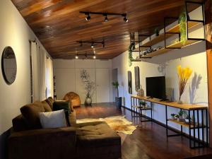 uma sala de estar com um sofá e uma televisão em Mansao gloria em Joinville