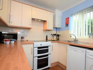 a kitchen with white cabinets and a white stove top oven at 2 Bed in Mundesley 75398 in Mundesley