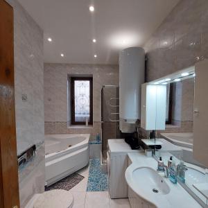 a bathroom with a tub and a sink and a bath tub at Luxury Apartments Darvina Street in Kyiv