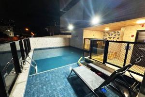 uma piscina no topo de um edifício à noite em Apartamento Alto Padrão Jatiúca - Maceió - Alagoas em Maceió