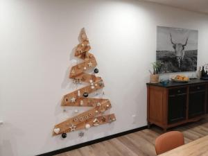 un árbol de Navidad en la pared de una sala de estar en Gîte du noisetier aux Granges du Vilaret, en Clairvaux-les-Lacs