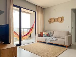 sala de estar con sofá y ventana grande en Bossa Mar Apartamento, en Bombinhas