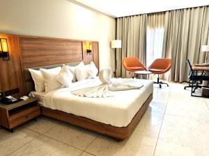 a hotel room with a bed and a desk and chairs at The Sky Imperial Hotel Kailash in Jamnagar