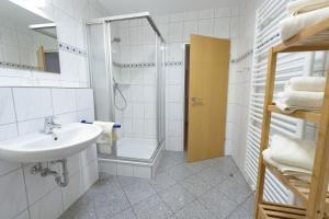 a bathroom with a sink and a shower at Kiefernglück App 7 in Norderney