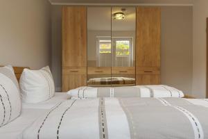 two beds in a bedroom with a mirror at Kiefernglück App 7 in Norderney