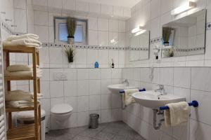 a bathroom with two sinks and a toilet and a mirror at Kiefernglück App 7 in Norderney