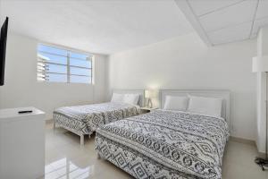een witte kamer met 2 bedden en een raam bij Beachfront 2 bedroom at Tides Hollywood 8th floor in Hollywood