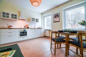 a kitchen with white cabinets and a table with chairs at CITYSTAY Gdynia Śródmieście Apartament z sauną in Gdynia