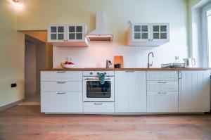 a kitchen with white cabinets and a sink at CITYSTAY Gdynia Śródmieście Apartament z sauną in Gdynia