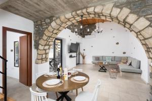 een woonkamer met een tafel en een stenen muur bij La Casa Di Pietre 1 in Kiotari