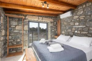 een slaapkamer met een groot bed in een stenen muur bij La Casa Di Pietre 1 in Kiotari +19 foto's