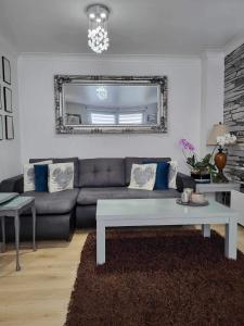 sala de estar con sofá y espejo en Beautiful apartment in SW London, en Sutton