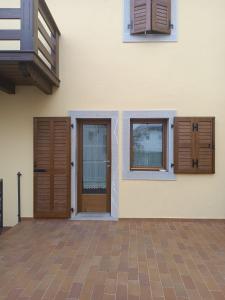 een huis met houten deuren en ramen erop bij Appartamento della Nonna in Sùtrio