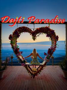 a woman sitting on a swing in a heart sign at DAJTI PARADISE RESORT in Tirana