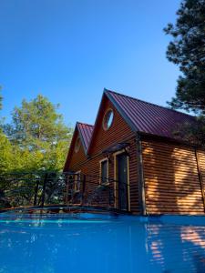 uma casa com uma piscina em frente em DAJTI PARADISE RESORT em Tirana