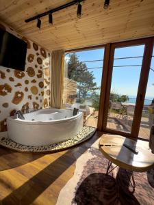DAJTI PARADISE RESORT في تيرانا: حوض كبير في غرفة مع نافذة كبيرة
