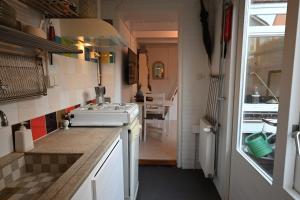 a small kitchen with a stove and a sink at Zomerhuisje Wijk aan Zee in Wijk aan Zee