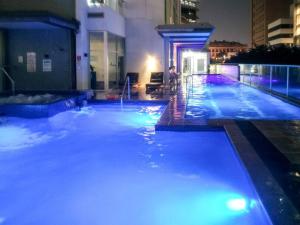 a swimming pool with blue lights in a building at Location! Inner City 1B1B Apt w/Pool,Gym, Sauna in Brisbane