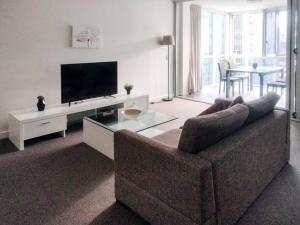 a living room with a couch and a flat screen tv at Location! Inner City 1B1B Apt w/Pool,Gym, Sauna in Brisbane