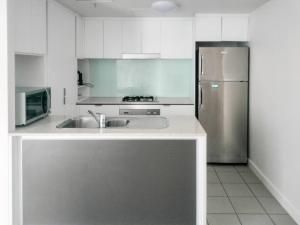 La cuisine est équipée d'un évier et d'un réfrigérateur. dans l'établissement Location! Inner City 1B1B Apt w/Pool,Gym, Sauna, à Brisbane