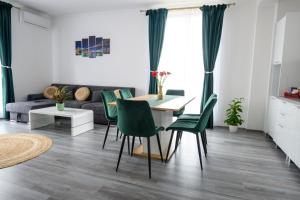 a living room with a table and green chairs at Apartament Radiana in Baile Felix