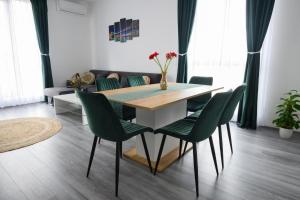 a dining room with a table and green chairs at Apartament Radiana in Baile Felix