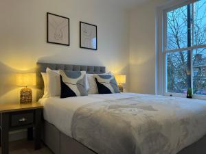 um quarto com uma cama grande e uma janela em South Street Apartments em Isleworth