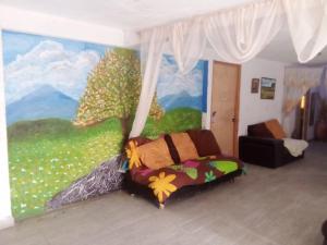 um quarto com um mural de uma árvore e uma cama em Tequex em Xochimancan