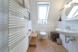 a white bathroom with a sink and a toilet at Up Süderdün 15 - Whg 1 in Norderney