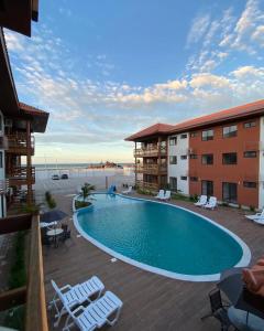 a pool at a hotel with chairs and condos at Vila Atlântida Beach in Luis Correia