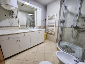 een badkamer met een wastafel, een douche en een toilet bij SKY DWELLING TIRANA in Tirana