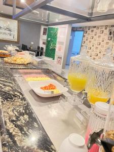 un mostrador con algo de comida y vasos de zumo de naranja en Itaipu Hotel, en Foz do Iguaçu