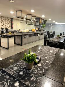 a large kitchen with a table with a plant on it at Itaipu Hotel in Foz do Iguaçu