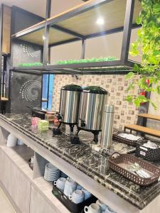 a kitchen counter with three pots and pans on it at Itaipu Hotel in Foz do Iguaçu