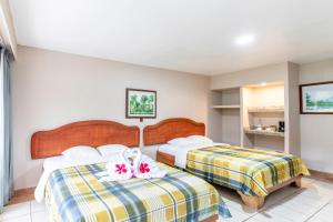 um quarto de hotel com duas camas com flores em Hotel Lavas Tacotal em Fortuna