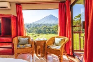 a room with a table and chairs and a view of a mountain at Hotel Lavas Tacotal in Fortuna