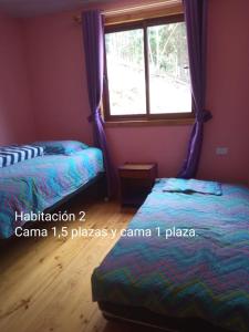a bedroom with two beds and a window at Casa Los Queñes in Navidad