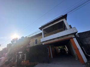 een gebouw met een garage met de zon erachter bij Hotel Princess Inn in Agua Azul