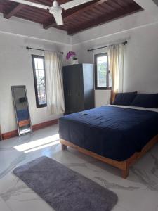 een slaapkamer met een groot bed in een kamer met ramen bij Hotel Princess Inn in Agua Azul