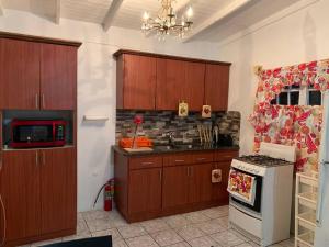 een keuken met houten kasten en een fornuis bij Casita de Campo/ Peace Cottage 