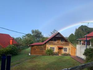 a house with a rainbow in the background at Cabaña Mamá Elia in Trinidad