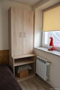 a bedroom with a cabinet and a window with a red toy at Rochatka in Rabka-Zdrój