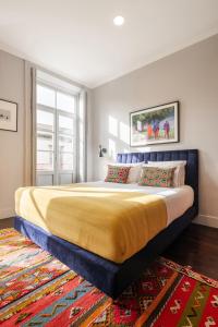 a bedroom with a large bed with a yellow blanket at Utopian Hotel, a charming guesthouse in Porto